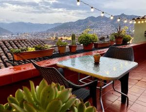 een tafel en stoelen op een balkon met planten bij Eco Home View - Guest House in Cuzco