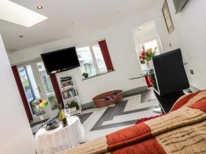 
a living room filled with furniture and a tv at Chapel Green Studio in St Austell

