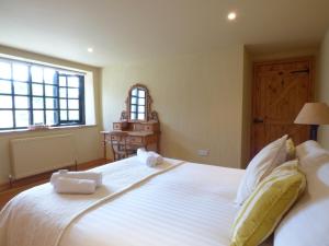 a bedroom with a large white bed with towels on it at Meadow Cottage in Fowey