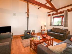 a living room with a couch and a fireplace at Kingfisher Barn in Liskeard
