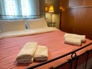 łóżko z dwoma ręcznikami na górze w obiekcie My House w Salonikach