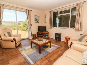 ein Wohnzimmer mit Sofa und Tisch in der Unterkunft The Shack in Mawgan Porth