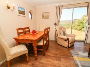 a dining room with a table and chairs and a window at The Shack in Mawgan Porth