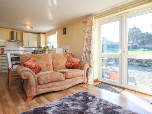 a living room with a couch and a large window at Sunny Cabin in Tintagel