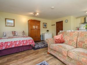 a living room with a bed and a couch at Sunny Cabin in Tintagel