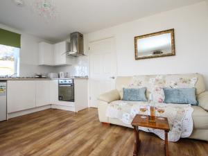 a living room with a couch and a table at Sunset Cottage in Tintagel