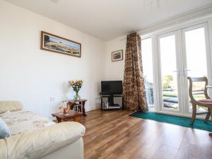 a living room with a couch and a tv at Sunset Cottage in Tintagel +13 photos