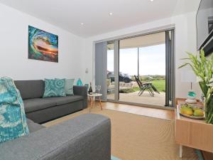 - un salon avec un canapé et une porte coulissante en verre dans l'établissement Saltwater, à Newquay