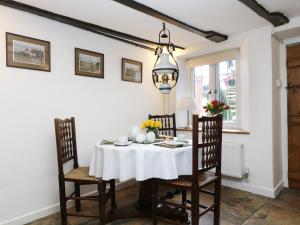 een eetkamer met een tafel en stoelen en een kroonluchter bij 13 Castle Hill in Lostwithiel