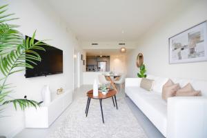 uma sala de estar com um sofá branco e uma mesa em Cozy 1-1 BR Steps from Downtown Doral Park em Miami
