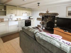 a living room with a couch and a stone fireplace at Longview Cottage in Bugle