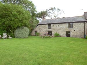 an old stone house with a picnic table in the yard at Old Winery Cottage in Golant