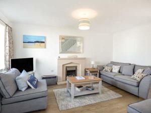 a living room with two couches and a fireplace at 7 Harlyn Cottages in St Merryn