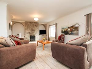 a living room with two couches and a table at Tregiffian Vean in Trevilley