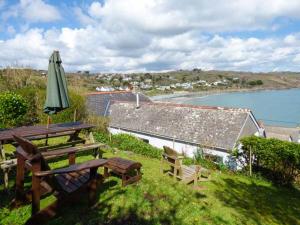 a patio with an umbrella and a table and chairs at Pretoria in Coverack