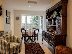 a dining room with a table and a large cabinet at The Coach House in Bodmin