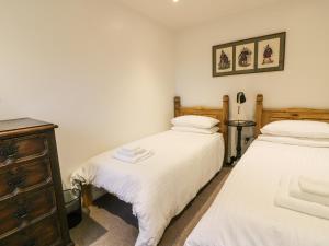 a bedroom with two beds and a dresser at The Coach House in Bodmin