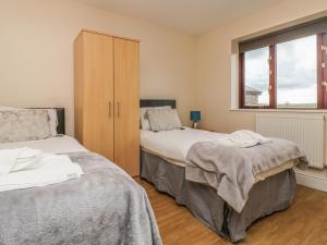 a bedroom with two beds and a cabinet at Shoreline in Marazion