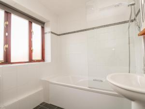 a white bathroom with a tub and a sink at Shoreline in Marazion +12 photos