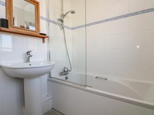 a bathroom with a sink and a shower and a tub at Surfside in Marazion +17 photos