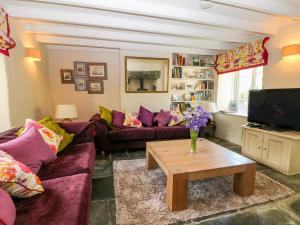 a living room with purple couches and a coffee table at Parwin in Tintagel