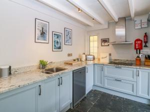 a kitchen with white cabinets and granite counter tops at Parwin in Tintagel