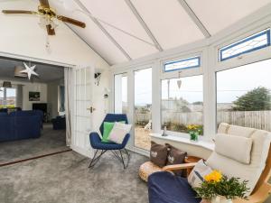 a living room with a ceiling fan and windows at Bethany Bay View in Cubert