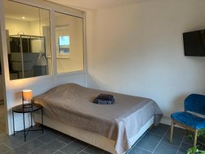 um quarto com uma cama, uma cadeira e uma janela em Juna em Bargteheide