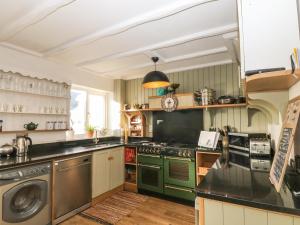 uma cozinha com um fogão e uma máquina de lavar louça em Quayside Cottage em Portreath