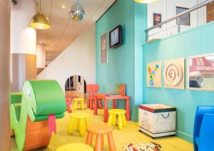 a room with colorful chairs and tables and tables at Appartement proche Disneyland, Val d'Europe, Paris #2 in Serris