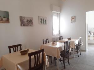 una sala da pranzo con due tavoli, sedie e una finestra di B&B Amèlie a Lecce