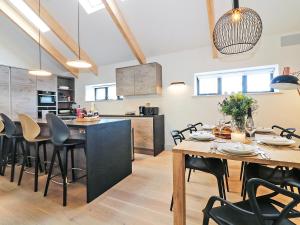 a kitchen and dining room with a table and chairs at Pig House, Boskensoe Barns in Helford Passage