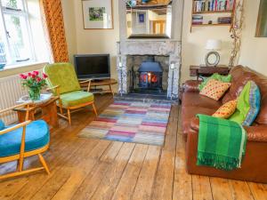 a living room with a couch and a fireplace at Sandy Cottage in Linton