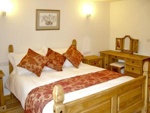1 dormitorio con cama grande y escritorio de madera en Happy Union Stables, en Abbey-Cwmhir
