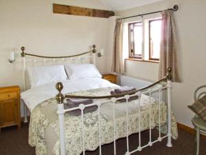 a bedroom with a white bed and a window at Bushmills in Bacton