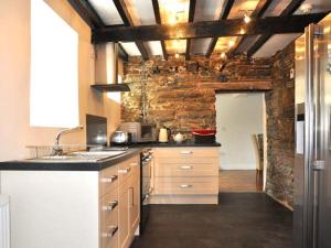 a kitchen with a counter and a brick wall at Hendre Aled Farmhouse in Llansannan