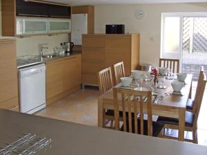 a kitchen with a wooden table and chairs and a kitchen with a tableablish at Rosewaters Cottage in Shrawley