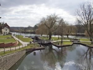 a river in a park with trees and a building at Rosewaters Cottage in Shrawley +8 photos