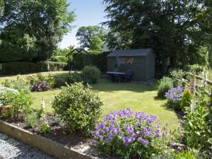 een tuin met een tuinhuisje in de tuin bij Church Barn in Tissington