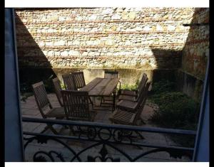 una mesa de madera con sillas y una pared de piedra. en Grande maison ancienne simple et spacieuse. en Vichy