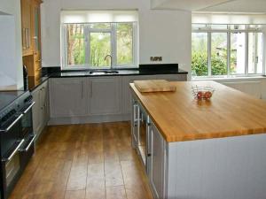 a large kitchen with a wooden counter top in it at Llechwedd in Dolgellau