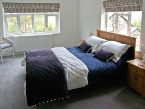 a bedroom with a bed with blue sheets and pillows at Llechwedd in Dolgellau