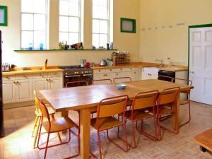 a large kitchen with a wooden table and chairs at The Methodist Chapel in Whiteparish