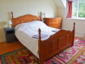 EilにあるBaldow Cottageのベッドルーム(木製ベッド1台、ドレッサー付)