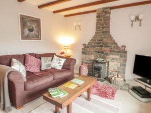 a living room with a couch and a fireplace at Lynton House in Drybrook