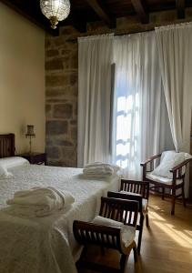 a bedroom with two beds and a large window at CASA RURAL LARRAZURIA ENEA in Labastida