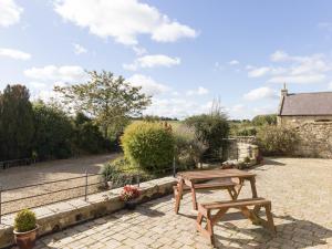 a picnic table and bench on a brick patio at Ridge Cottage in Longwitton