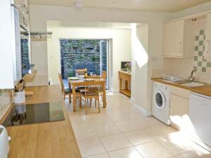a kitchen and dining room with a table and a washing machine at Rothay Cottage in Ambleside