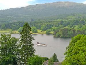 a boat on a lake in the middle of a valley at Rothay Cottage in Ambleside