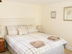 a bedroom with a bed with two towels on it at Piggery Cottage in Wigton